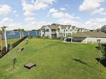 A grassy area with a fence and a body of water in the background.